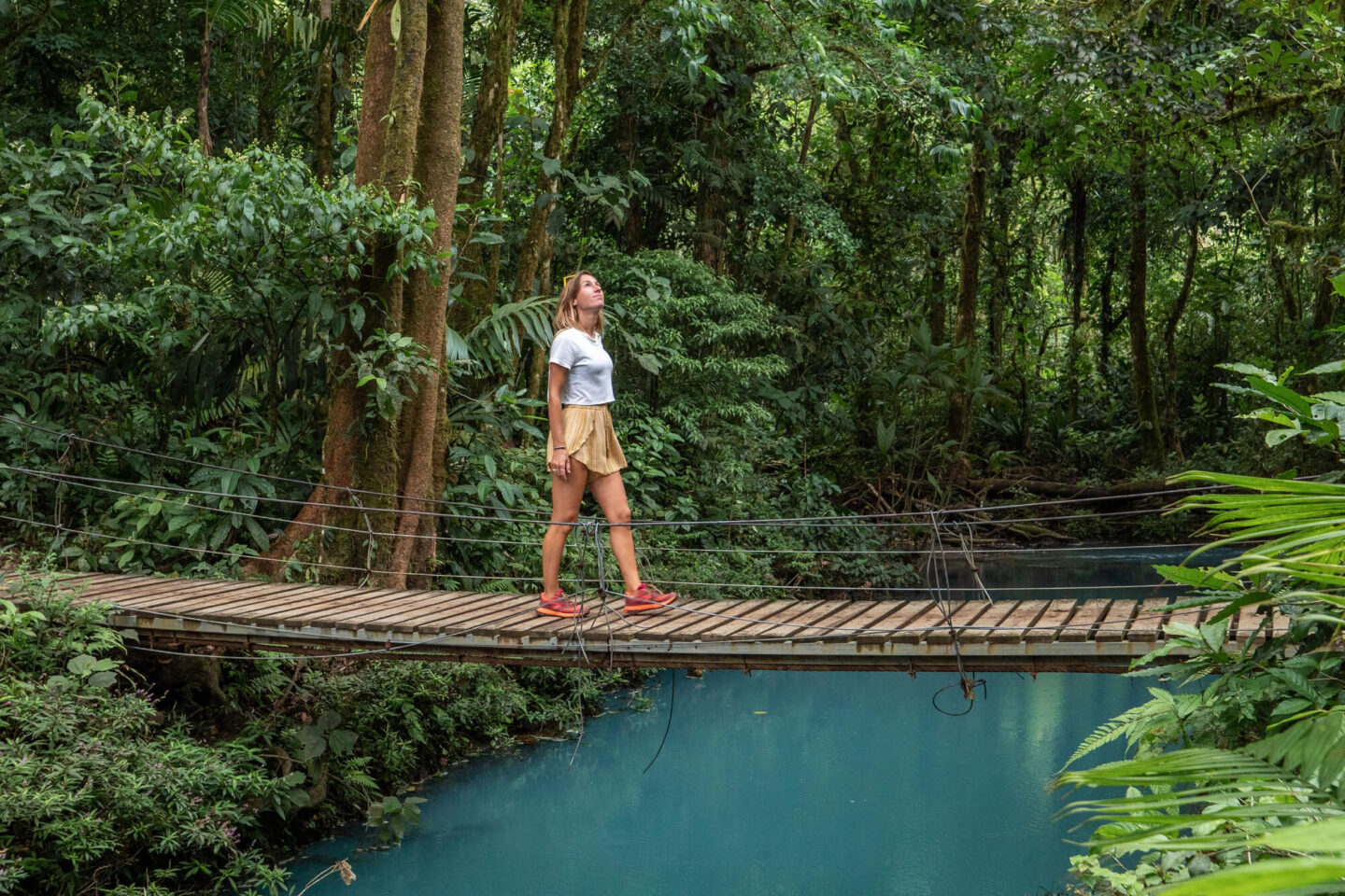 costa-rica-woman-walking-over-bridge-in-jungle-istk