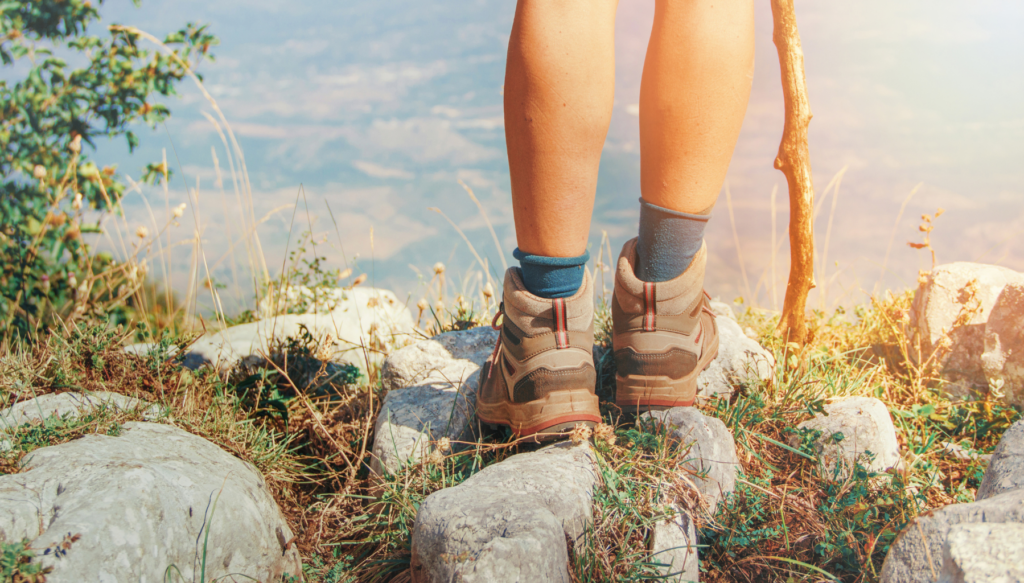 Picture of someone standing on a cliff wearing hiking boots and socks