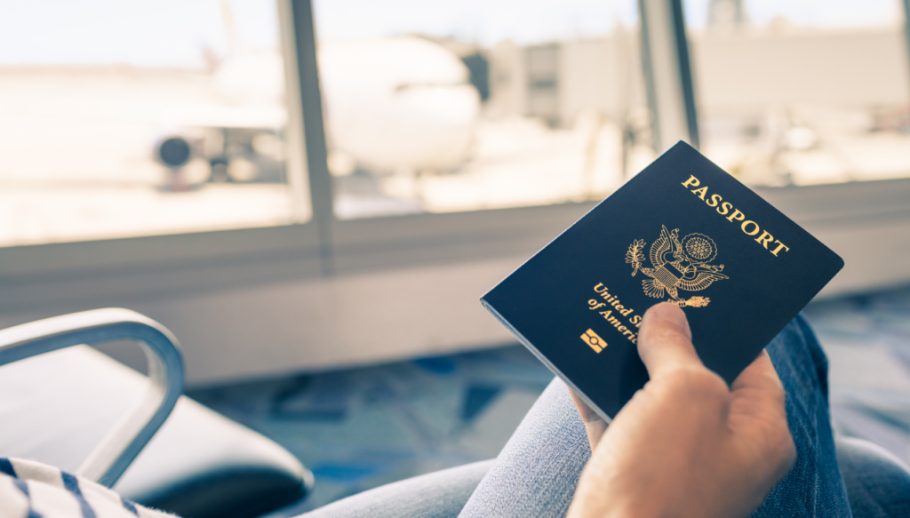 Picture of passport being held with airport in background