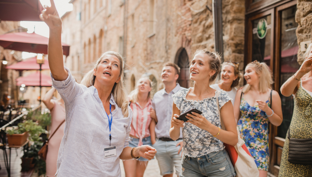 Picture of a tour guide pointing upwards to show group of students
