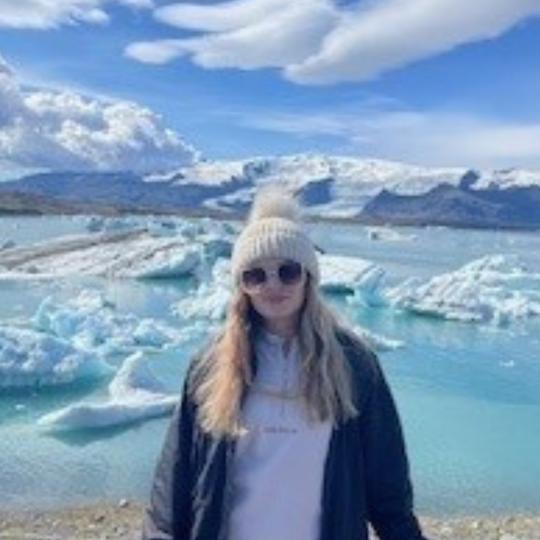 Picture of a person stood in front of a glacier lagoon