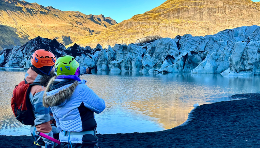 Picture of school students beneath sólheimajökull glacier in Iceland next to the glacier pool