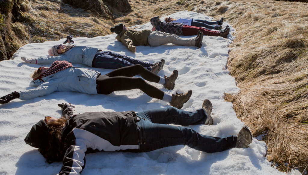 School students lying down in the snow in Iceland