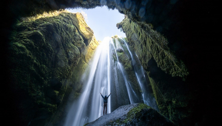 Picture of person underneath hidden waterfall in Iceland