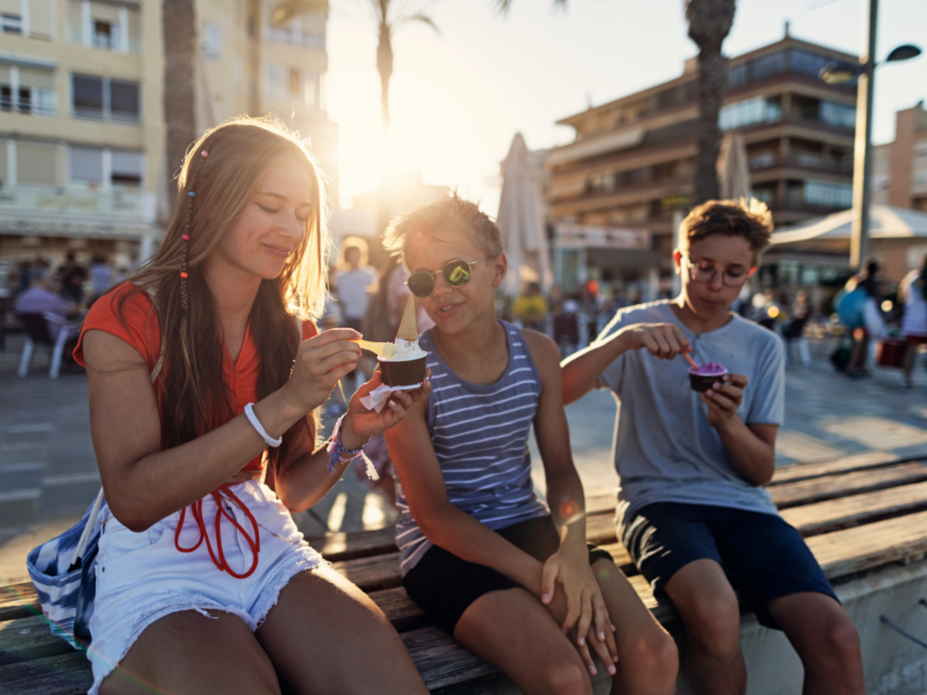 Picture of people sat on a wall eating ice cream