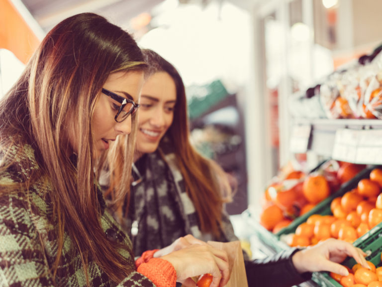 Picture of two students looking at oranges in a market