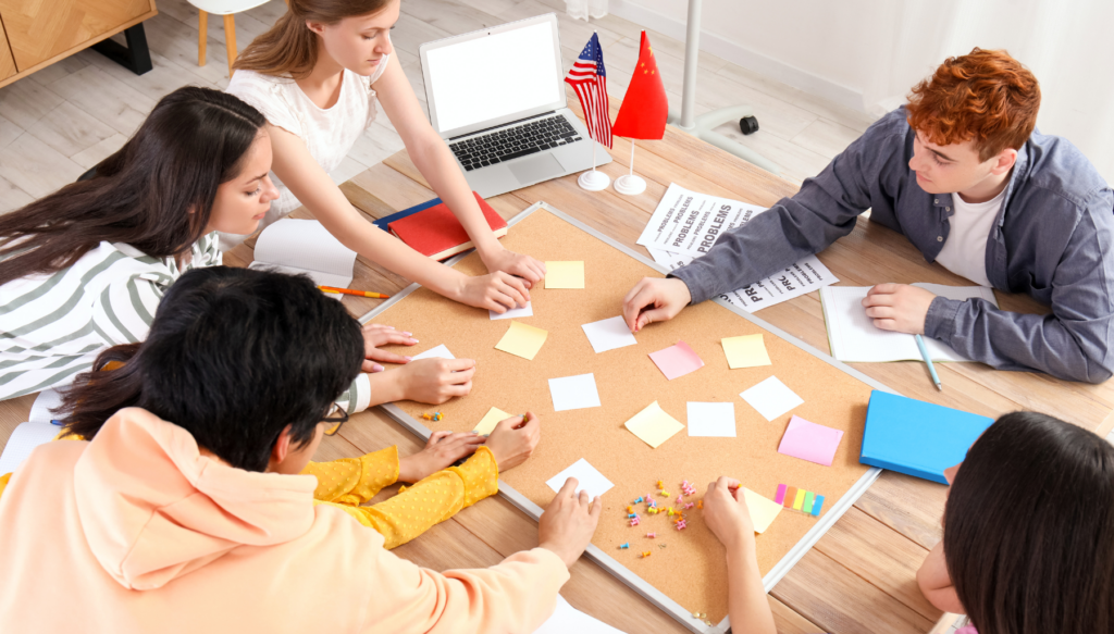 Picture of students pointing to post it notes on a desk